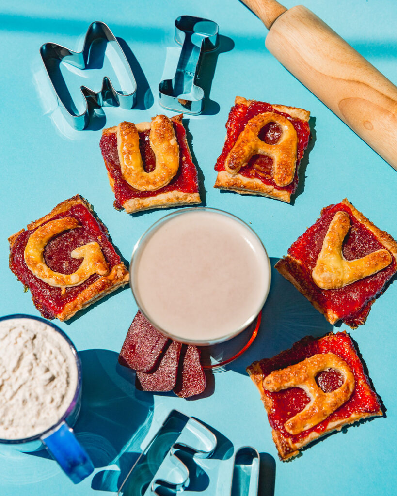 An aerial view of guava pastries surrounding a glass of guava beer.