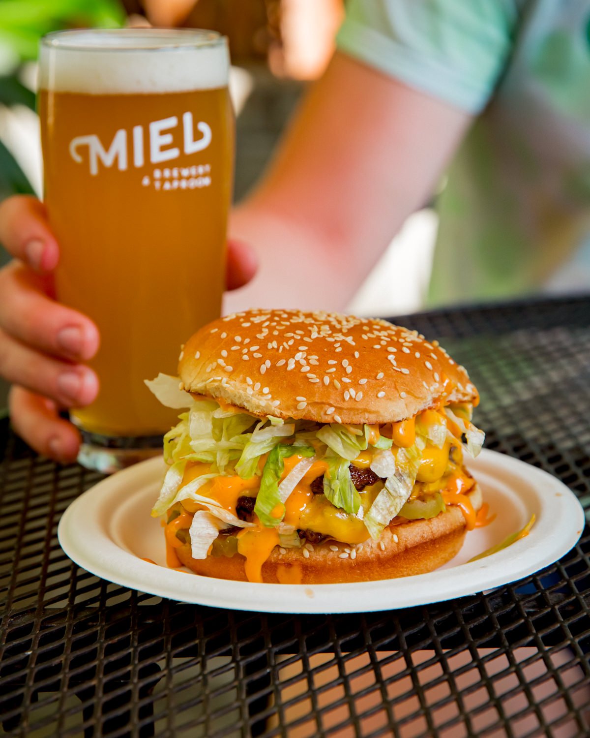 A cheeseburger and a glass of Miel beer